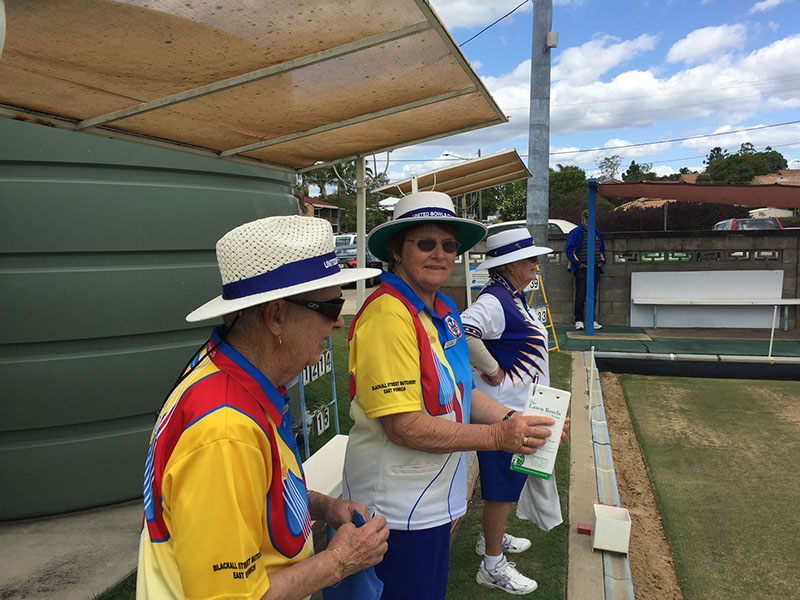 Members relaxing in the shade beside the green